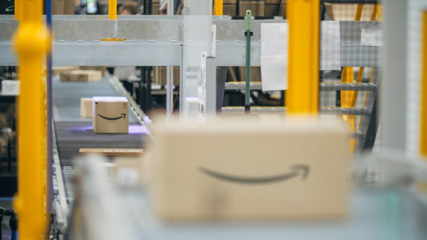 Amazon shipping boxes moving along a conveyor belt in a warehouse.