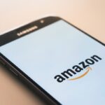 Smartphone displaying the Amazon logo on its screen.