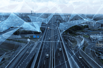 Cars driving on a highway with a digital network overlay representing connected infrastructure.