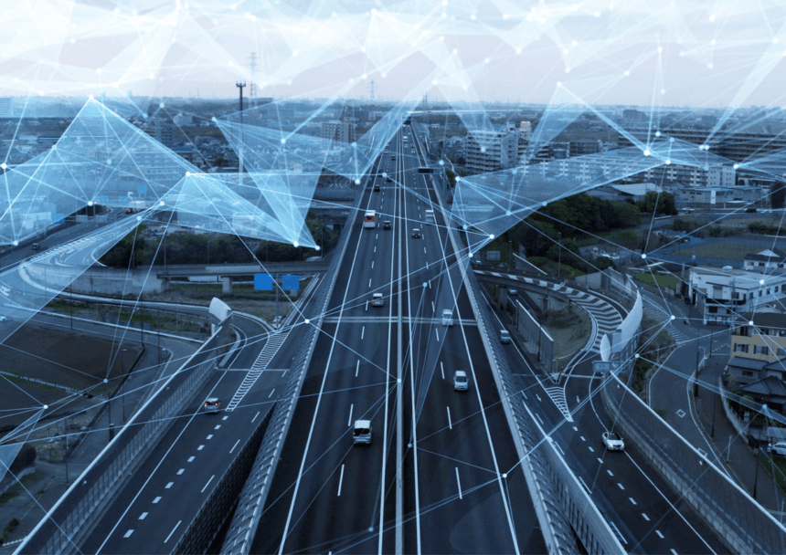 Cars driving on a highway with a digital network overlay representing connected infrastructure.