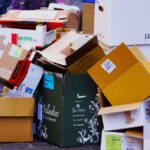 A pile of stacked cardboard boxes on a city street.