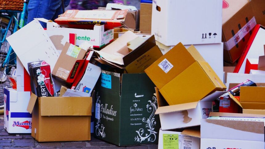 A pile of stacked cardboard boxes on a city street.