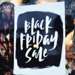 A Black Friday Sale sign displayed in a shop window decorated for the holidays.
