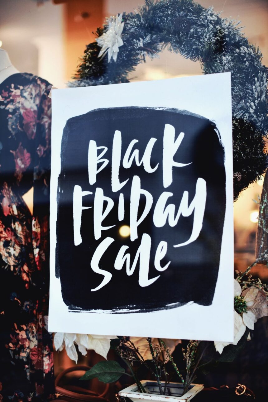 A Black Friday Sale sign displayed in a shop window decorated for the holidays.