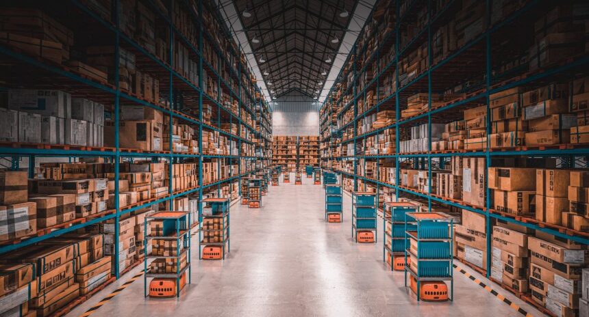 Autonomous robots transport shelves through aisles of a large, well-stocked modern warehouse.