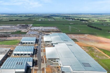 Aerial view of large industrial warehouse complex under construction in a rural landscape.