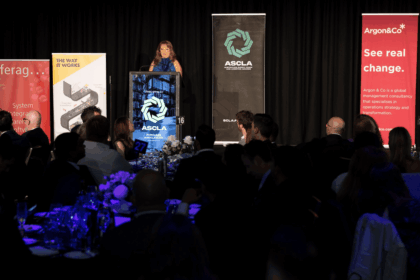 A woman speaking at a podium at the ASCLA awards ceremony before an audience.