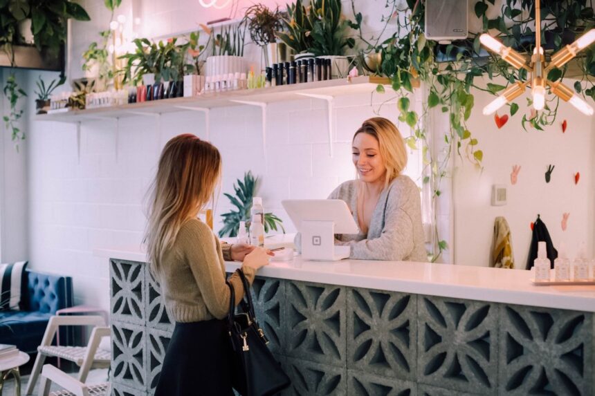 Customer paying for products at a boutique counter with a smiling staff member.
