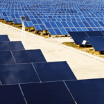 Rows of solar panels arranged in a large, modern renewable energy farm.