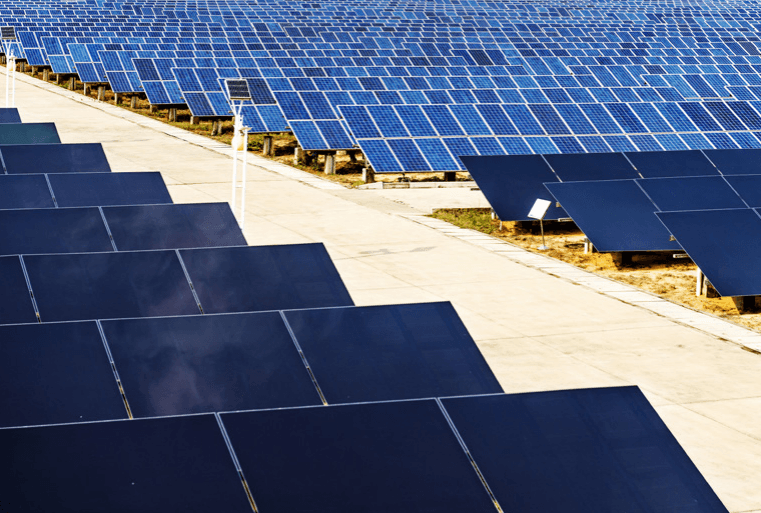 Rows of solar panels arranged in a large, modern renewable energy farm.