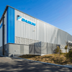Exterior view of a modern Daikin industrial warehouse building under a clear blue sky.
