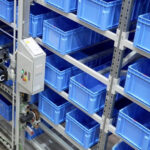Dematic Multishuttle FD system handling blue storage totes in an automated warehouse shelving system.