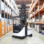 A Dematic automated forklift operating in a large, high-bay warehouse.
