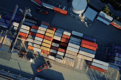 Aerial view of a busy shipping yard with organized rows of stacked cargo containers.