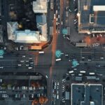Aerial view of a city intersection with digital map pins overlaid on traffic.