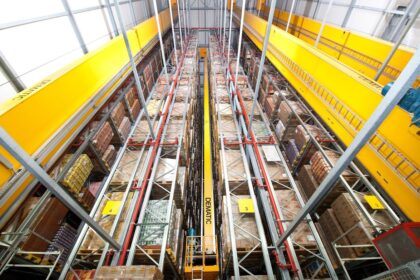High-angle view of a modern automated warehouse with tall, organized storage racks.