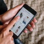 Person browsing a clothing store app on a smartphone.