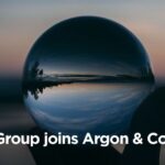 Hand holding a crystal ball reflecting a sunset, with text Intent Group joins Argon & Co ANZ.