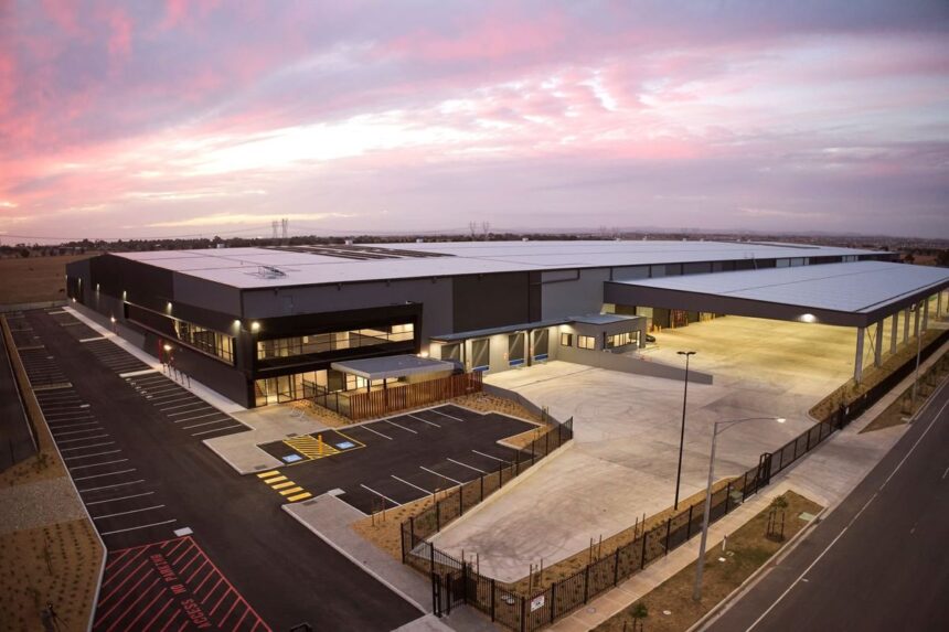 Aerial view of a large modern warehouse building at sunset.