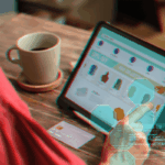 Person shopping online on a tablet with digital code overlay and a credit card.