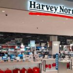 Interior view of a well-lit Harvey Norman electronics store with various displays.