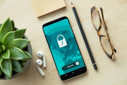 A smartphone showing a secured padlock icon on a desk with accessories.