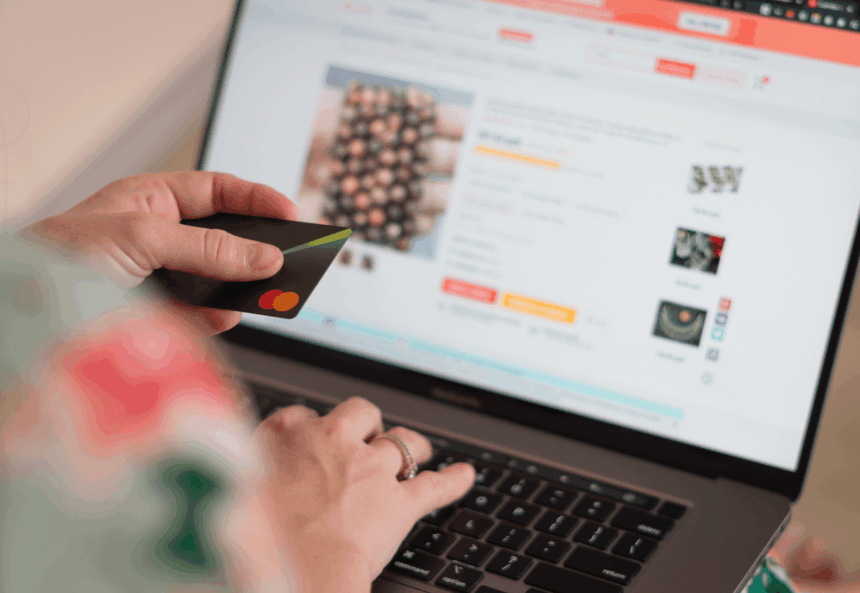 Person shopping online on a laptop while holding a credit card.