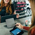 A customer paying for items with a credit card at a beauty salon checkout.