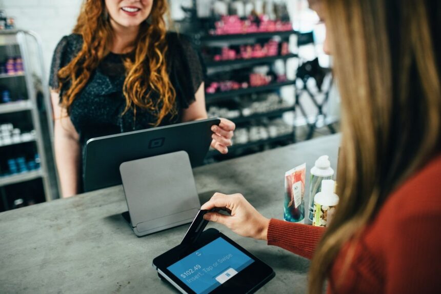 A customer paying for items with a credit card at a beauty salon checkout.