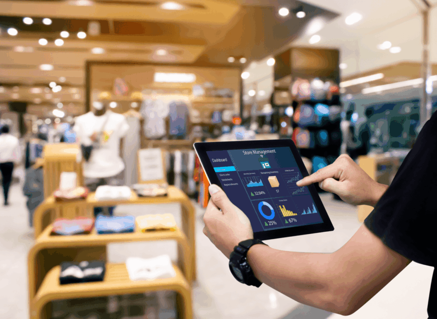 A person uses a tablet displaying a store management dashboard in a clothing store.