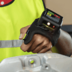 Warehouse worker wearing a hands-free wearable barcode scanner on their hand.