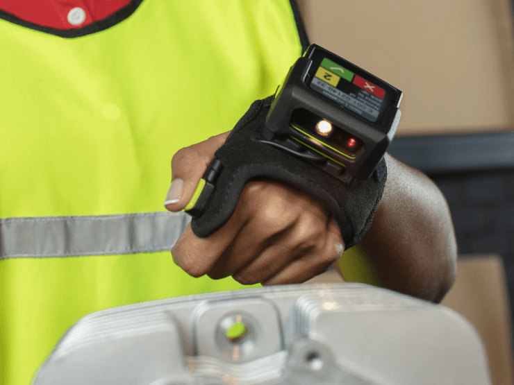 Warehouse worker wearing a hands-free wearable barcode scanner on their hand.