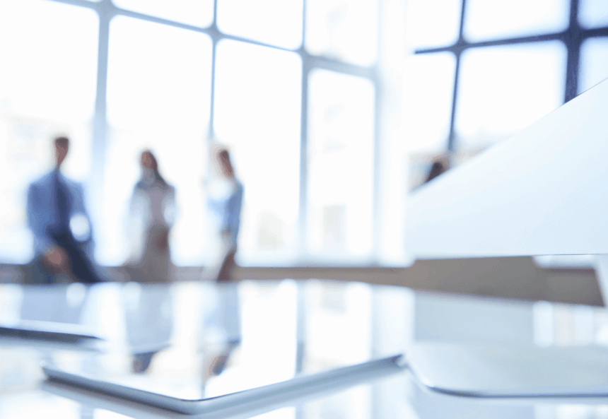 A blurred office background with a modern white desk in the foreground.
