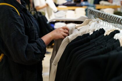 A person browsing clothing on a retail rack.