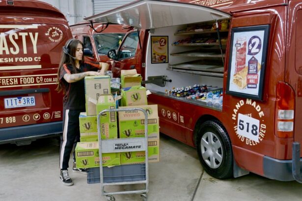 A worker loading boxes into a Tasty Fresh Food Co. catering van.