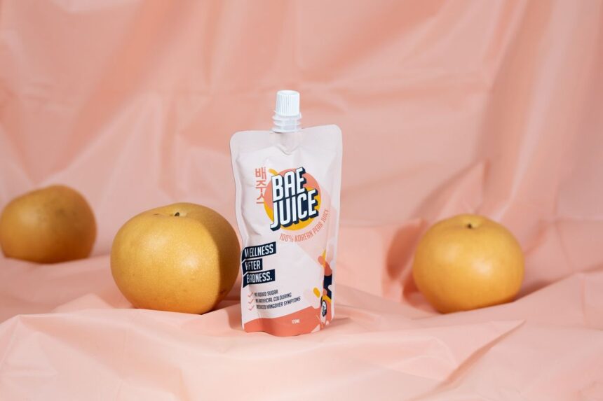 A pouch of Bae Juice Korean pear juice surrounded by three fresh pears.