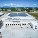 Aerial view of a Maersk warehouse facility with solar panels and loading docks.