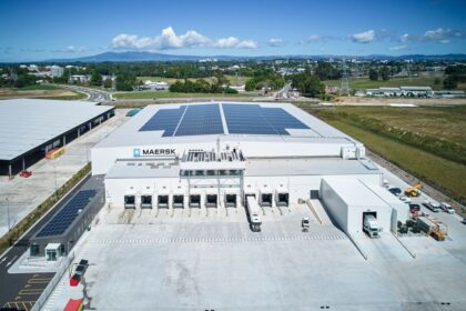 Aerial view of a Maersk warehouse facility with solar panels and loading docks.