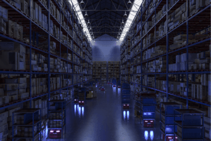 Automated robots transporting shelving units through a large, dimly lit warehouse.