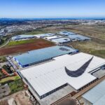 Aerial view of a Nike warehouse complex featuring a large swoosh logo on the roof.