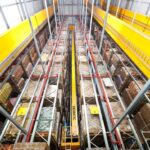 High-angle view of a modern automated warehouse with tall, organized storage racks.