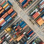 Aerial view of a shipping yard filled with colorful stacked freight containers.