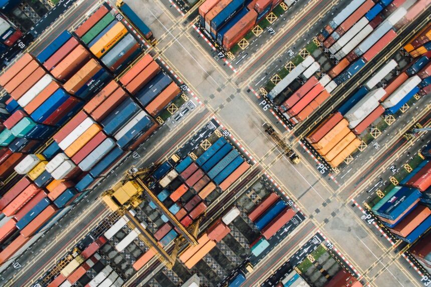 Aerial view of a shipping yard filled with colorful stacked freight containers.