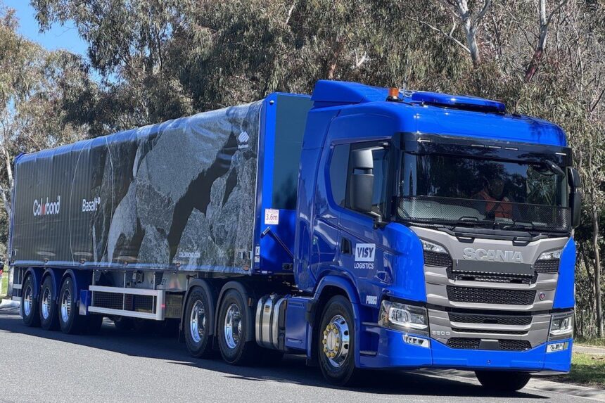 A blue Scania truck with a Colorbond-branded trailer parked on a road.