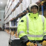 Worker wearing high-visibility gear in a cold storage warehouse.
