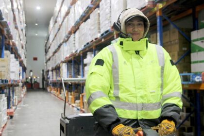 Worker wearing high-visibility gear in a cold storage warehouse.