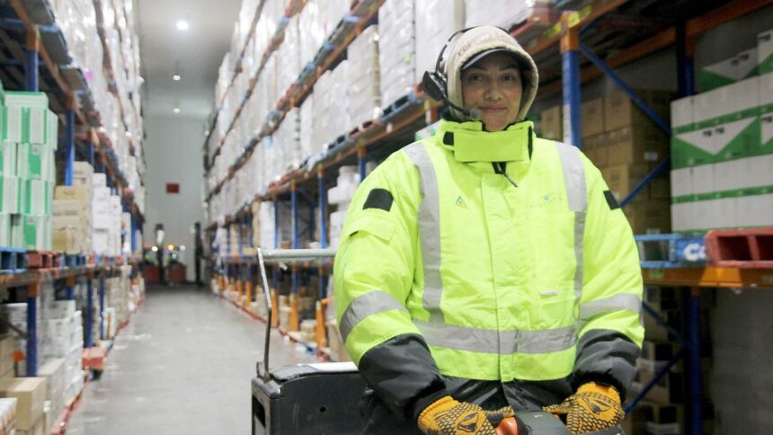 Worker wearing high-visibility gear in a cold storage warehouse.