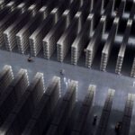 High-angle view of an expansive warehouse with rows of shelves and forklifts.