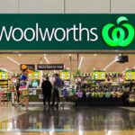 Entrance to a Woolworths supermarket store with customers shopping inside.
