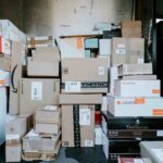 The cargo area of a delivery van is filled with stacked cardboard parcels and retail shipping boxes of various sizes, ready for transport and last-mile delivery.